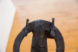 Textured dark vintage African buffalo sculpture, showing deeply carved spiral patterns and upper adornments.