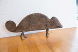 Full profile of a vintage African chameleon figure with a textured body and spiral tail.