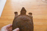 Detailed view of the vintage iron turtle's head, showing simple features and a heavy rust patina.