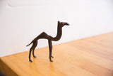 Vintage African camel sculpture in profile view, showcasing dark, textured patina.