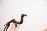 Profile view of the dark patina on a vintage handmade African camel sculpture.