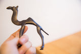 The dark patina and sculptural form of a vintage African camel held in hand.