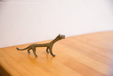 Angled side view of the vintage African cheetah's slender body and oxidized texture.