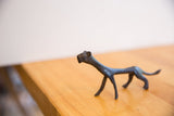 Side view of the vintage cheetah figure showing its slender form and dark patina.