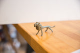 Side view of a vintage African lion collectible with an oxidized green patina and handmade texture.