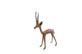 Vintage handmade African gazelle sculpture standing with tall horns and a rustic patina.