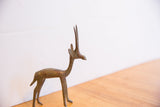 Side profile of a handmade vintage African gazelle showing its slender form and aged metal patina.