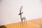 Vintage African gazelle sculpture highlighting its slender build and oxidized finish.