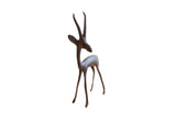 Vintage African gazelle sculpture with a slender body, tall horns, and a dark, brightly oxidized finish.