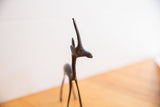 The dark oxidized patina and handmade texture on a vintage gazelle's slender horns and head.
