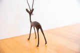Back view of the African gazelle sculpture showing its dark patina and textured tail.
