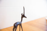 Smooth, dark patina on the slender neck and head of the vintage gazelle figure.