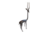 Vintage right-facing African gazelle sculpture with a stylized slender body and dark patina.