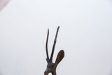 Close-up of the vintage gazelle's slender horns showing a dark, textured patina.