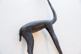 Dark, smooth patina over the hand-carved body of a vintage gazelle figure.