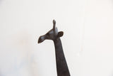 Profile of a vintage African giraffe's head showing its hand-carved details and dark patina.