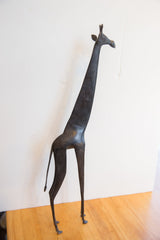 Vintage African giraffe sculpture with a dark patina, showing its full, slender form.
