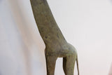 Close-up of vintage African giraffe figurine, showing textured body with time-softened patina.