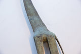 Close-up of vintage African giraffe figure's legs, showing textured bronze-green patina.