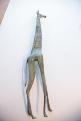 Lower half of the vintage African giraffe sculpture, showing slender legs and time-softened patina.