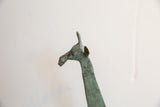 Textured green oxidized patina on the head of a vintage African giraffe figurine.