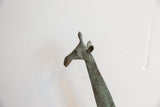 Profile view of the vintage giraffe head highlighting its textured, oxidized surface.