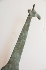 Detailed profile of the vintage giraffe's head highlighting its textured, oxidized green patina.