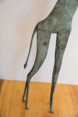 Close-up of the slender tail and hind legs of the oxidized giraffe figurine.