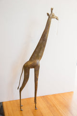 Side profile of a vintage African giraffe collectible, showing its full elongated form.