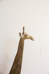 Upward angle on the sculpted head of a vintage African giraffe, showing its brass patina.