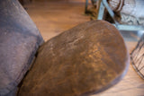 Dark wood seat of the vintage African slot chair, highlighting textured grain and signs of use.
