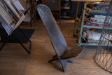 Vintage carved slot chair with dark aged wood texture and interlocked base.