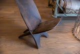Dark, aged wood texture on a vintage African slot chair's seat and back.