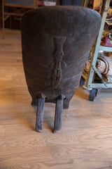 Rustic dark wood back of vintage African birthing stool with carved animal.