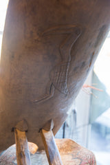 Stylized bird hand-carved with a cross-hatch pattern on the vintage wooden chair back.
