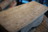 Hand carved Senufo stool's light wood surface, showing natural grain and texture.