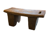 Vintage hand carved African wooden stool with dark wood grain and carved slot.