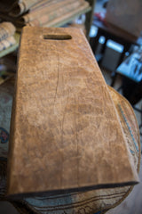 Vintage hand-carved Senufo stool's top surface with visible wood grain and age cracks.