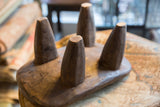 Detailed view of the worn, hand-carved texture on the stool's four conical legs.