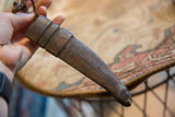 The rich, dark patina and hand-formed shape of a vintage leather sheath.