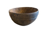 Vintage wooden African bowl with a dark, aged patina and hand-carved geometric details.