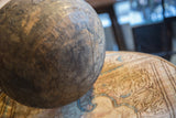 Aged patina and visible cracks detail the surface of a vintage wooden bowl.