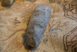 Weathered surface and elongated shape of an antique Neolithic primitive stone tool.