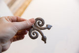 Vintage African double snake pendant held in hand, showing its sculptural form and scale.