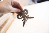 Vintage African double crocodile pendant with a rustic texture held in hand.