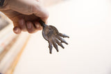Vintage African crocodile pendant held in hand, showing its scale and aged patina.