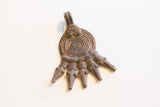 Overhead view of the vintage pendant's textured bail and incised spiral body.
