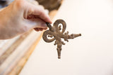 Vintage African double crocodile pendant held in hand to show its scale and texture.