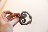 Vintage double snake pendant held to show its rustic texture and scale.