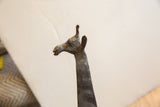 Detailed profile view of the vintage African giraffe's textured, sculpted head.